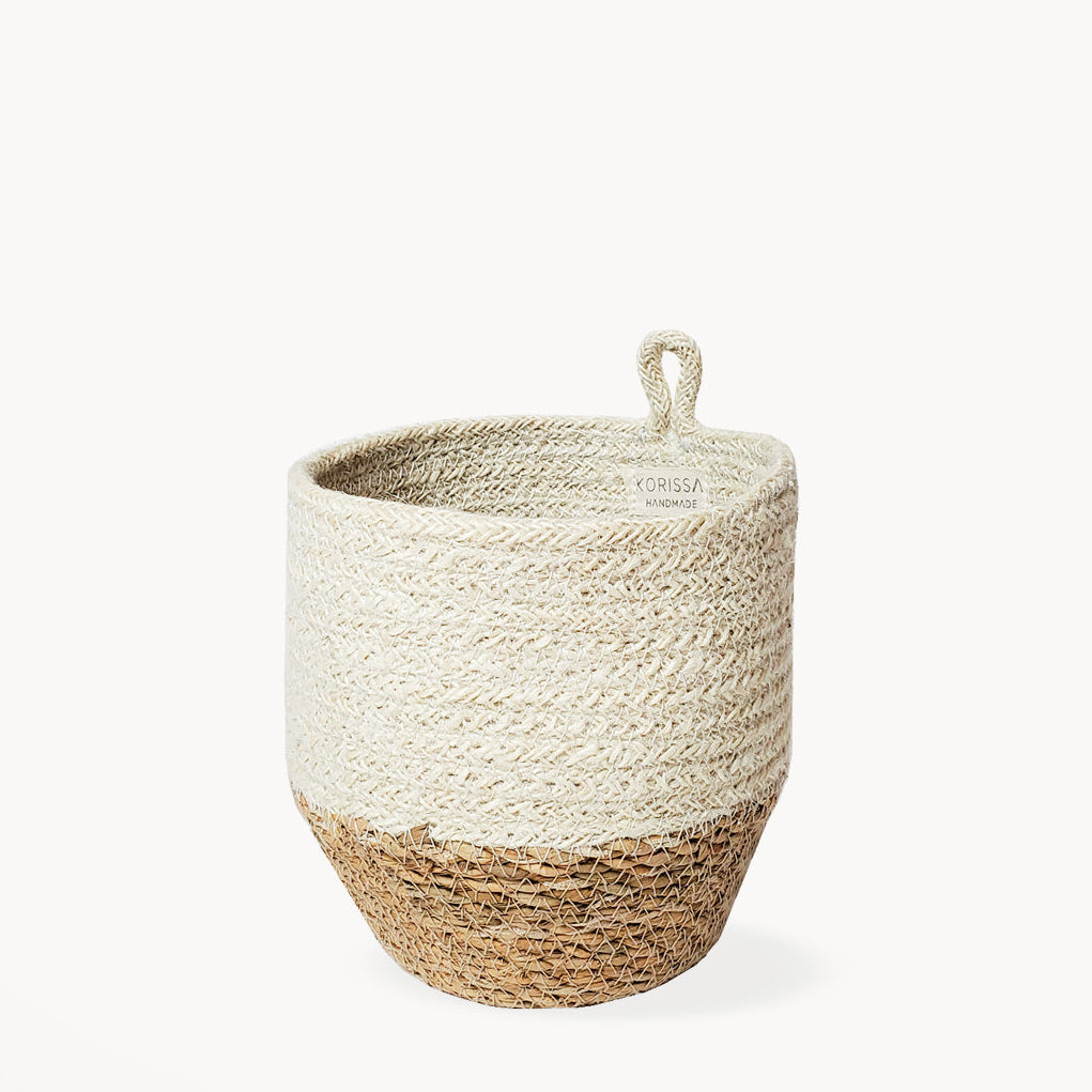 Woven basket with two-tone white and natural design with a hanging loop on a white background