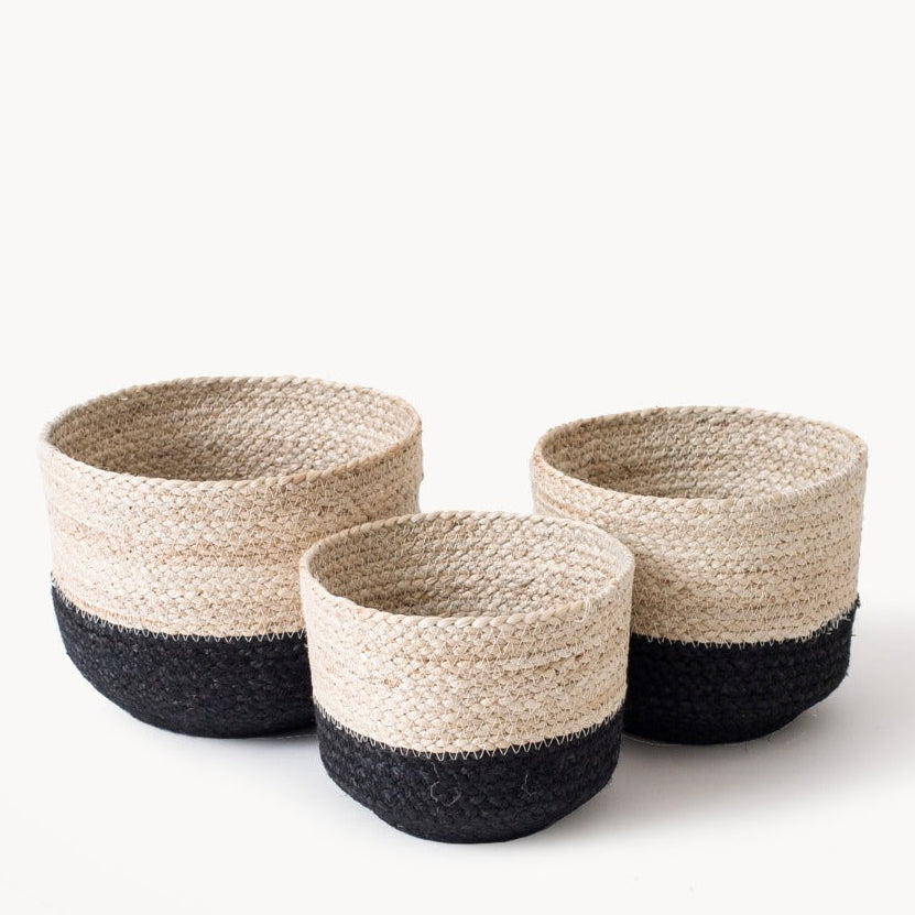Three woven jute baskets with black and natural color on a white background