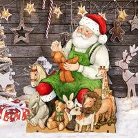 A festive Christmas scene featuring a Santa Claus figure seated among plush toys, with a wooden horse, giraffe, reindeer, wrapped gifts in Santa's workshop.