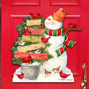 Red door with a Christmas-themed snowman door hanger saying JOY, Peace, LOve surrounded by festive garlands.