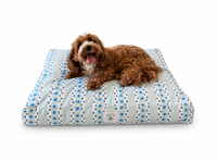 Dog lying on a Designer Pet Bed with a Modern Tribal Boho design in Blue,Gray,White,Black with a white background