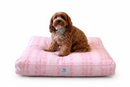 A small brown dog sits on a rectangle Designer Pet Bed in a Romantic Pink Simple Floral pattern on a white background.