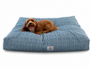 A small brown dog lies on a large Designer Pet Bed with a Modern Coastal, Navy & White Simple Plaid design on a clean white background.