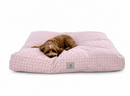 A small brown dog lies curled up on a large rectangle Designer Pet Bed in All girly Pink with a Coquette, Hyper Feminine style, photographed on a clean white background.