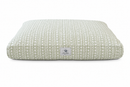 A rectangular pet bed with a textured, woven vertical stripe pattern in sage green and white, featuring a small white brand label on the front.