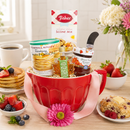 Red mixing bowl baking gift basket filled with Pancake, Waffle and Scone mix, Jam, and Maple Syrup.