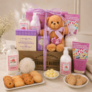 Gift basket with Tea Rose Bubble Bath (8.8oz.), Tea Rose Body Lotion (9.1oz.), Bath Salts (9oz.); Strawberry Lemonade Drink Mix (1oz.). Jack Allen Snickerdoodle Cookies (2oz.), Jack Allen Butter mints (0.8oz.), Angelina's Butter Cookies (6 oz.), 6-inch Plush Teddy Bear with flowers and a bow in a rustic wood crate