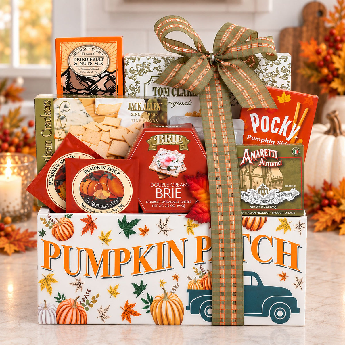 An Autumn Treats Gift Basket for Thanksgiving and Fall with Food and Snacks including Pocky Amaretti sticks, Brie double cream cheese, Jack Daniel's, and pumpkin spice cookies, arranged in a white box with autumn illustrations.