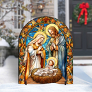 Decorative nativity scene with stained glass style art in front of a snowy outdoor background.