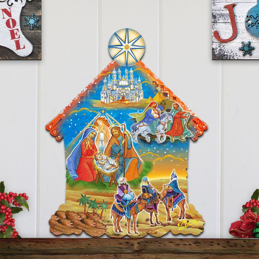 Decorative nativity scene wall hanging with three wise men and baby Jesus on a white wooden panel background.