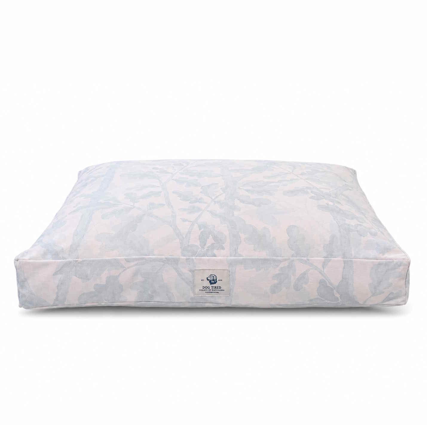 A designer dog bed with an ivory and gray botanical pattern, on a plain white background.