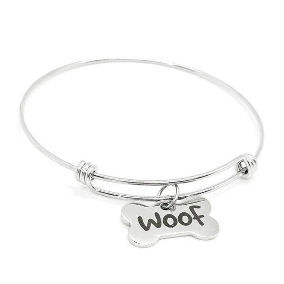 Silver bracelet with a bone-shaped charm that says 'Woof' on a white background
