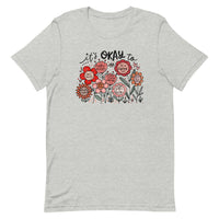 light gray unisex t-shirt with encouraging saying "it's okay to be different" in red, pink floral design