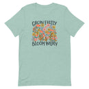 light blue/green Unisex T-shirt with be yourself message "Grow Freely Bloom Wildly" in a field of wildflowers