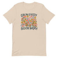 beige Unisex T-shirt with be yourself message "Grow Freely Bloom Wildly" in a field of wildflowers