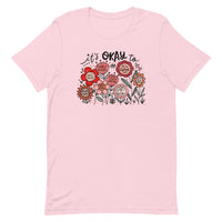 pink unisex t-shirt with encouraging saying "it's okay to be different" in red, pink floral design